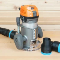 Black ToolCurve 1-7/8 in. hose adapter on a Ridgid 2 HP fixed base router's dust port, spare adapter beside it