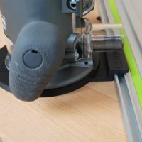 Guide rail adapter mounted on Ridgid 2 HP router, attached to aluminum track with green edge guard