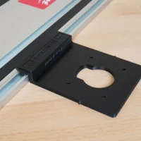 Black plastic guide rail adapter mounted on Festool track rail, with oval cutout for router base and mounting holes visible