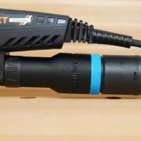 Black hose adapter with blue band attached to MAXXT sander dust port, showing threaded connection and braided hose