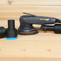 Black ToolCurve 1-7/8 inch hose adapter with blue ring shown loose beside one fitted to a MAXXT sander's rear dust port