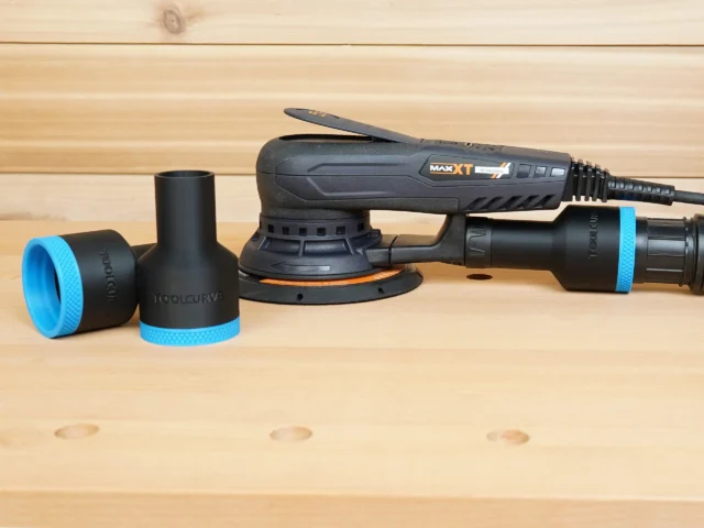Black ToolCurve 1-7/8 inch hose adapter with blue ring shown loose beside one fitted to a MAXXT sander's rear dust port