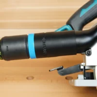Black hose adapter with blue band attached to Makita 36v cordless circular saw dust port, next to Festool hose