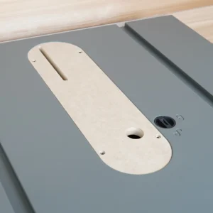 Cream-colored zero clearance insert for Hercules 10" table saw, installed on gray table saw top, showing central blade slot and mounting holes