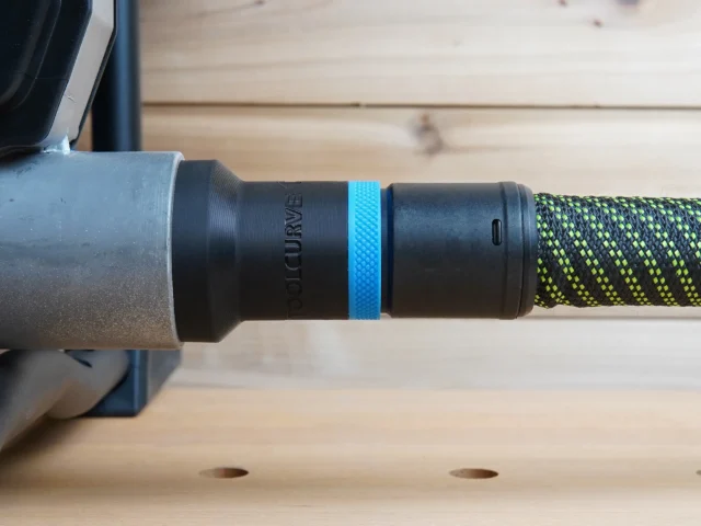 Hose adapter attached to Hercules table saw dust port, showing threaded connection with blue band and braided hose
