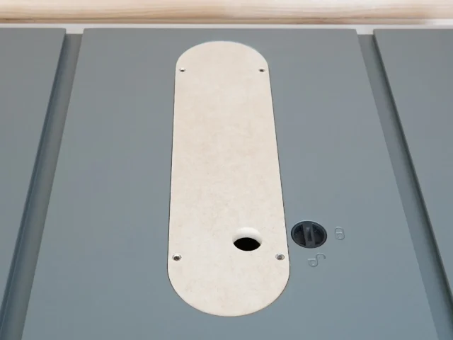 White MDF zero clearance insert for Hercules table saw, mounted on saw table with offset screws visible