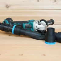 Black 1-7/8 inch hose adapter with blue collar joining a hose to a Makita grinder shroud, spare adapters beside