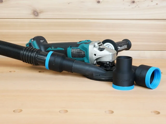 Black 1-7/8 inch hose adapter with blue collar joining a hose to a Makita grinder shroud, spare adapters beside
