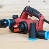 Black 1-1/4 inch hose adapter with blue ring joining an orange hose to a red SKIL planer, spare adapters alongside