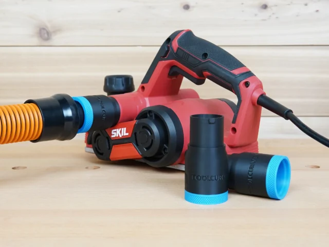 Black 1-1/4 inch hose adapter with blue ring joining an orange hose to a red SKIL planer, spare adapters alongside