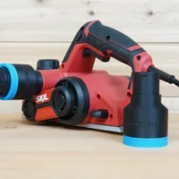 Black ToolCurve 1-7/8 in hose adapter with blue ring on red SKIL planer port, second adapter beside it