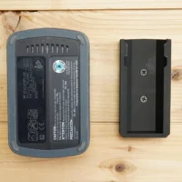 Black ToolCurve battery mount next to a Festool BP 18v battery, showing the mount's screw holes and slot for battery insertion