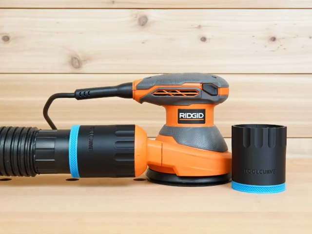 Black ToolCurve 2-1/2 inch hose adapter with blue band joining a vacuum hose to a Ridgid 5 in. sander, second adapter alongside