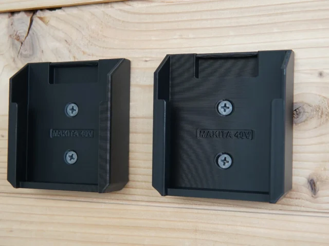 Two black plastic Makita 40V Max XGT battery mounts side by side, each with two screw holes and a slot at the top for battery insertion