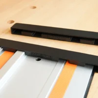Two black protective caps for Wen guide rails, one installed on a rail with orange and white sections, one shown separately above