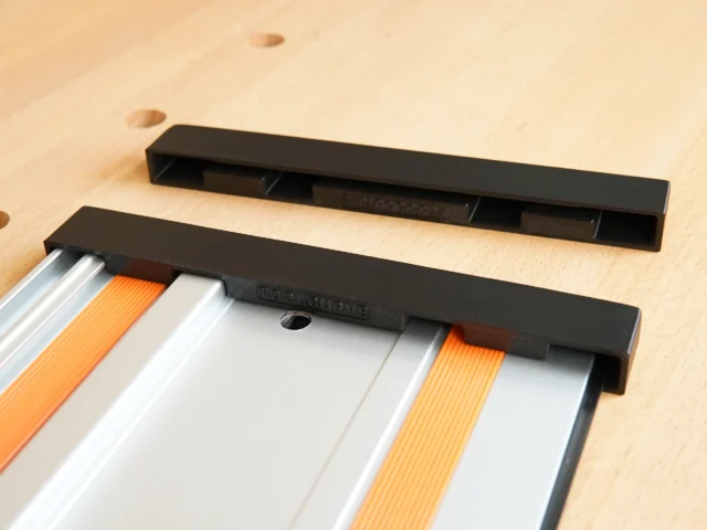 Two black protective caps for Wen guide rails, one installed on a rail with orange and white sections, one shown separately above