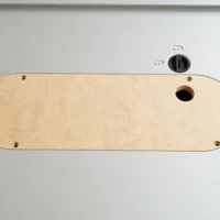 Light wood zero clearance insert for Kobalt table saw, mounted on saw top with four brass screws and one center hole for blade access