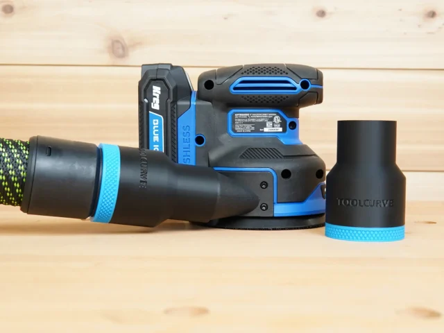 Black 36mm ToolCurve hose adapter with blue band joining a vacuum hose to a Kreg random orbit sander, second adapter beside it