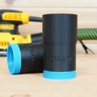 Black ToolCurve hose adapter with bright blue grip ring, shown alone and installed on a Dewalt palm sander in background