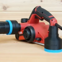 Black ToolCurve 2-1/2 inch hose adapter with blue trim on a red SKIL planer port, second adapter beside it