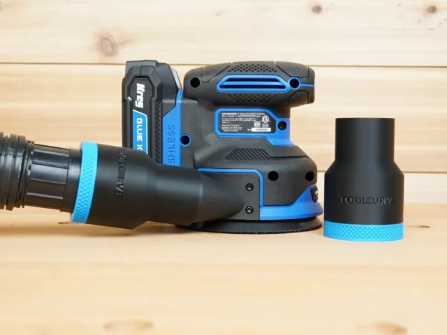 Black ToolCurve 1-7/8 inch hose adapter with blue band connected to a Kreg random orbit sander, second adapter beside it