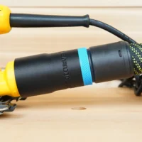 Black hose adapter with blue band attached to DeWalt yellow palm sander, connected to green braided hose