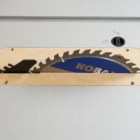 Light wood zero clearance insert with slot for saw blade, mounted on Kobalt 10" table saw with blue blade visible