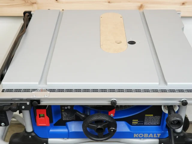 Natural wood zero clearance insert installed on Kobalt 10" table saw, with mounting holes and adjustment screw visible