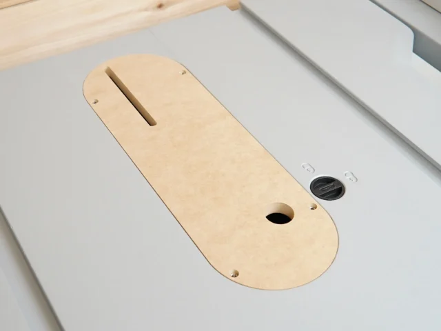 Zero clearance insert for Kobalt 10″ table saw, wood-colored MDF with slot for blade and mounting holes, shown installed in saw table