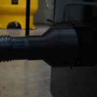 Black hose adapter with threaded 4-inch port on left end, connected to SawStop table saw dust collection port