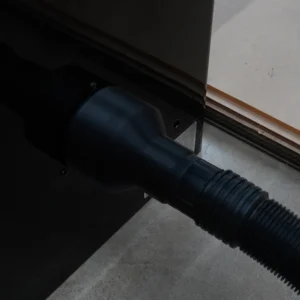 Black hose adapter fitted to a SawStop PCS 4-inch rear dust port with a ribbed 2-1/2 inch hose connected