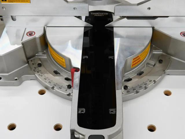 Black zero clearance insert installed on Dewalt 12-inch miter saw between the aluminum fences, viewed from above