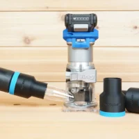 Black 36mm hose adapter with blue trim on a vacuum hose beside a Kreg 20v trim router and two spare adapters