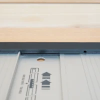 Black protective cap sliding onto end of Bosch aluminum guide rail, showing friction fit design