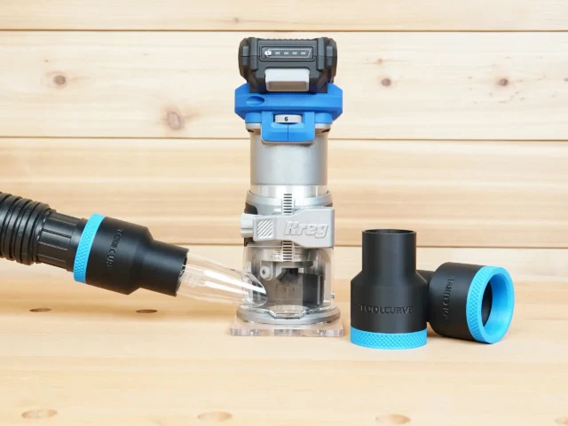 Black 1-7/8 inch hose adapter with blue cuff beside a Kreg 20v trim router and connected vacuum hose