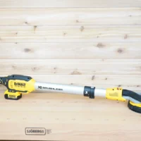 Yellow 1-1/4 inch hose adapter fitted to the dust port of a Dewalt 20v Max 9in drywall sander on a workbench