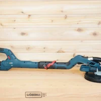 Bosch 9in drywall sander lying on a workbench, its dust port joined to a shop vac hose by the 2-1/2 inch adapter