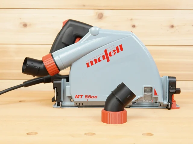 No Snag Dust Port adapter mounted on a Mafell MT 55cc track saw, with angled hose connector pointing upward and separate twist-lock adapter in foreground
