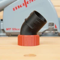 Black angled dust port adapter with orange twist-lock hose collar, displayed in front of a Mafell track saw