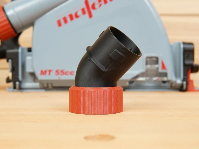 Black angled dust port adapter with orange twist-lock hose collar, displayed in front of a Mafell track saw