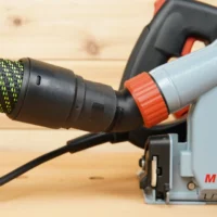 No Snag Dust Port adapter mounted on Mafell MT 55c track saw, with braided hose connected and angled upward away from the workpiece