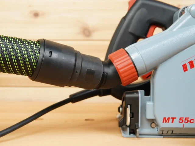 No Snag Dust Port adapter mounted on Mafell MT 55c track saw, with braided hose connected and angled upward away from the workpiece