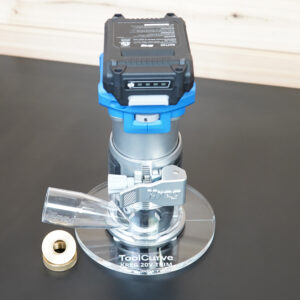 Clear 6-inch round acrylic guide bushing base plate mounted on a Kreg trim router, with a brass-colored guide bushing beside it