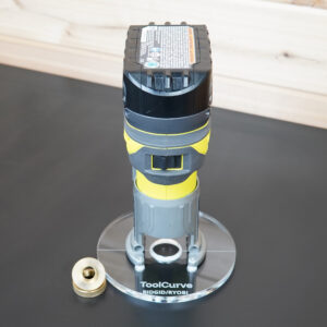 Clear 6 inch round acrylic guide bushing base plate mounted on a Ryobi trim router, with a brass guide bushing and lock nut beside it