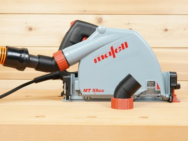 ToolCurve No Snag Dust Port adapter attached to a Mafell MT 55cc track saw, with vacuum hose connected, angling upward on light wood surface