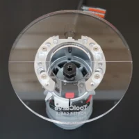 6-inch round clear acrylic router base plate for Porter Cable trim router, viewed from above, showing white mounting ring with brass screws, black motor hub, and red adjustment lever