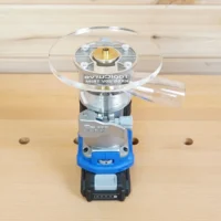 6-inch round clear acrylic base plate mounted on a Kreg trim router with blue housing, shown on a wooden workbench with pegboard