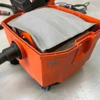 Macam reusable dust bag installed in an orange FEIN Turbo dust extractor, showing gray polyester fleece filter surface
