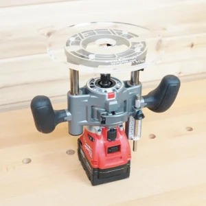 Clear 8-inch round acrylic router base plate mounted upside down on a Milwaukee M18 trim plunge router