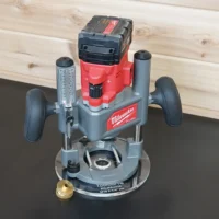 Milwaukee M18 2-1/4 HP plunge router on an 8-inch clear acrylic guide bushing base plate, brass bushing alongside